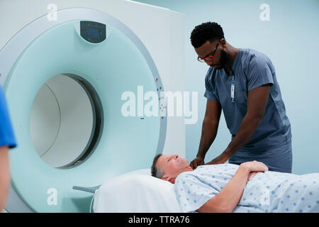 Medico preparazione paziente per MRI scan in ospedale Foto Stock