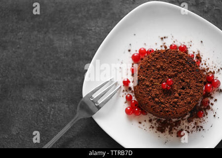 Gusto di cioccolato fondente con ribes rosso sulla piastra bianca, primo piano Foto Stock