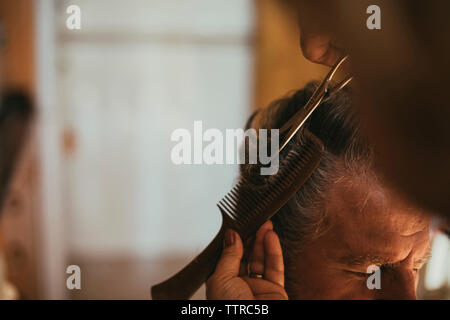 Immagine ritagliata del barbiere di taglio cliente maschio dei capelli Foto Stock