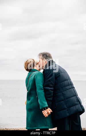Vista da dietro di una coppia di anziani kissing Foto Stock