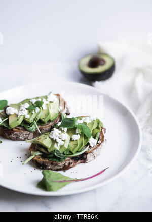 Close-up di avocado su diversi tipi di pane è servita nella piastra Foto Stock