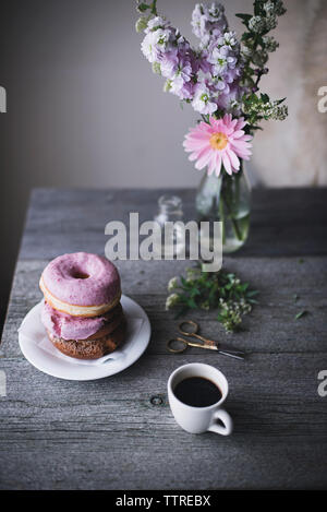 Angolo di alta vista di ciambelle e tazza di caffè sul tavolo a casa Foto Stock