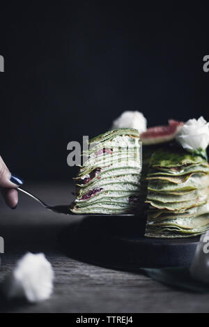 Immagine ritagliata della donna la rimozione di fetta di pancake Foto Stock