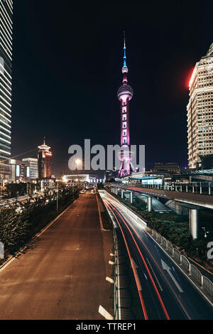 Percorsi di luce per la circolazione su strada accese contro la Oriental Pearl Tower nella città di notte Foto Stock