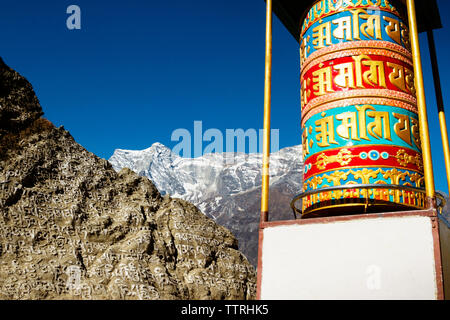 Basso angolo vista della grande ruota di preghiera a Mt. Everest contro il cielo blu chiaro Foto Stock