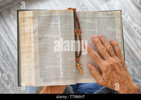 Il vecchio uomo di contenimento e leggere la Bibbia Foto Stock