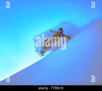 L uomo lo snowboard contro il cielo chiaro Foto Stock