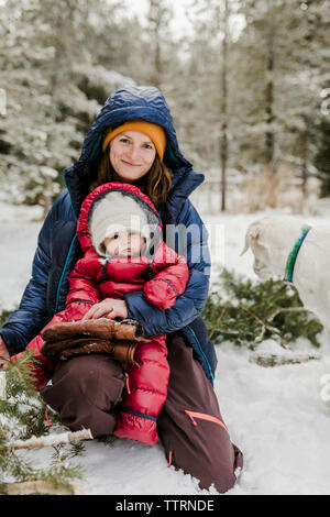 Ritratto della madre con la figlia nel bosco durante la stagione invernale Foto Stock