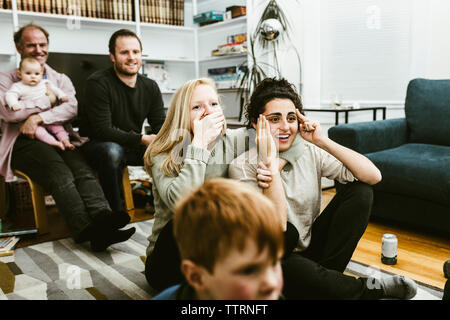 Multi-generazione famiglia a guardare la TV in soggiorno Foto Stock