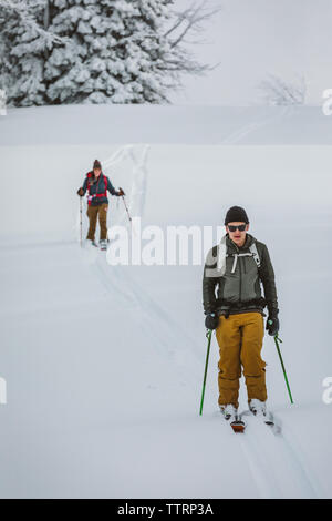 Gli sciatori in discesa della testa mentre la scuoiatura in Wyoming inverno backcountry Foto Stock