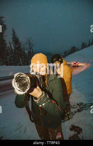 Femmina giovane fotografo sorrisi e scatta una foto con la fotocamera sporco Foto Stock