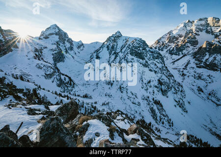 Tramonto dietro wintery scena prima del tramonto nelle montagne rocciose Foto Stock