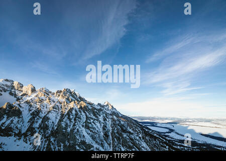 Montagne rocciose e le loro ombre come set di sole oltre il Jackson Hole valley Foto Stock