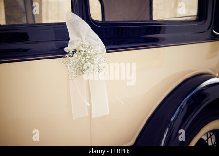 Fiori con velo appeso sul finestrino del veicolo Foto Stock