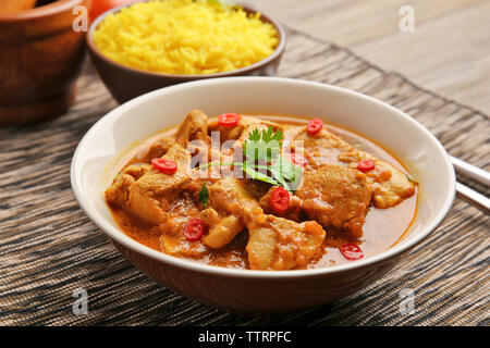Una gustosa cena con pollo al curry nella piastra sulla tavola Foto Stock