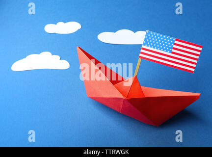 Barca di carta con la bandiera americana su sfondo blu. Felice il Columbus day concept Foto Stock