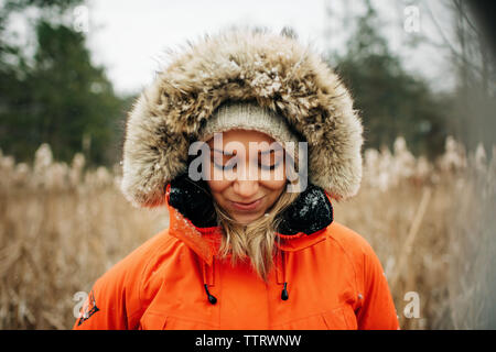 Ritratto di donna bionda nella neve con l'inverno cappello e il cappotto Foto Stock