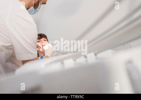 Dentista esaminando boy i denti in clinica medica Foto Stock