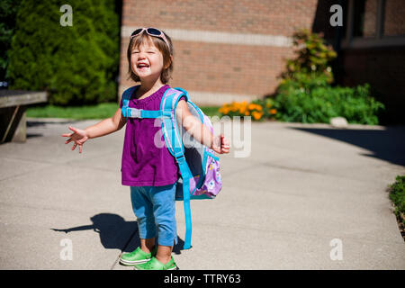 Ritratto di happy Baby girl con zaino in piedi sul sentiero durante la giornata di sole Foto Stock