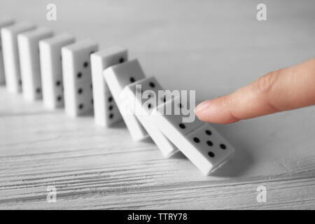 Femmina di spinta a mano di domino sul tavolo di legno Foto Stock