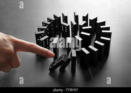 Femmina di spinta a mano di domino su sfondo grigio Foto Stock