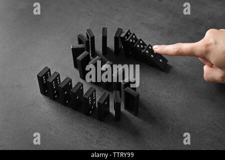 Femmina di spinta a mano di domino su sfondo grigio Foto Stock