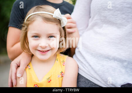 Ritratto di ragazza carina in piedi con la famiglia in cantiere Foto Stock