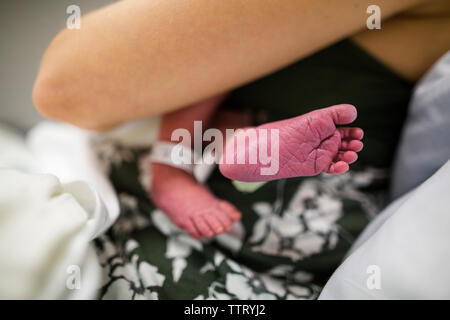 La vista dal basso di un neonato recante cullati nella sua madre di braccia Foto Stock
