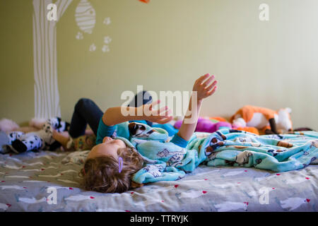 Bambina a letto. Il bambino a casa si sveglia a letto al mattino Foto stock  - Alamy