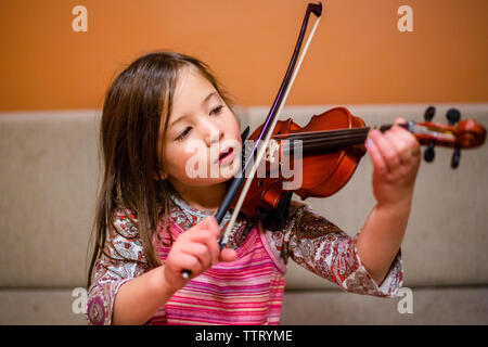 Ritratto di un concentrato bambina pratica violino Foto Stock