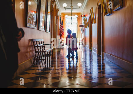 Due bambini stand nel corridoio di un edificio governativo Foto Stock