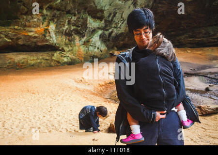 La sezione inferiore di una madre e un bambino seduto a piedi nudi sulla roccia nella gola Foto Stock