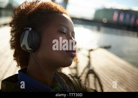 Close-up di donna rilassata con gli occhi chiusi ascoltando musica Foto Stock