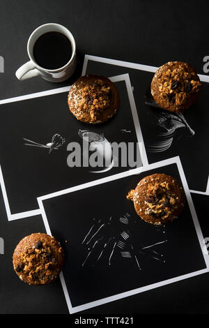 Angolo di alta vista di muffin con caffè e fotografie sul tavolo Foto Stock