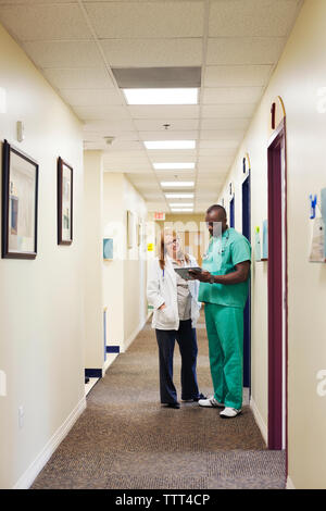 I medici a discutere mentre in piedi in corridoio Foto Stock
