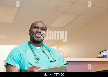 Basso angolo vista di felice medico con appunti Foto Stock