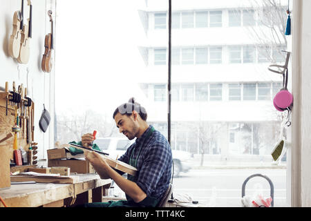 L'uomo facendo violino in officina Foto Stock