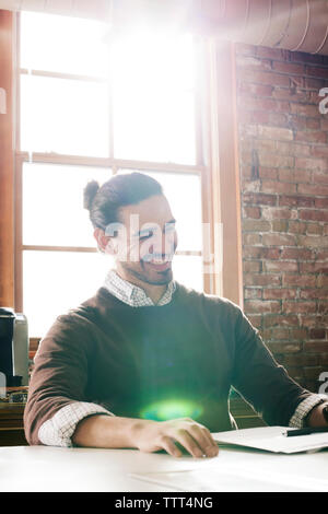 Happy businessman seduto in ufficio Foto Stock