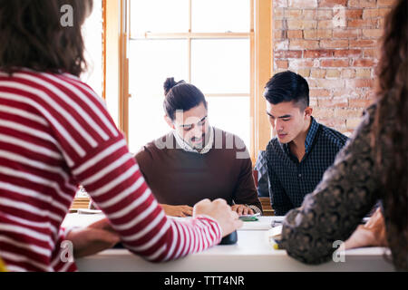 uomini d'affari e donne d'affari discutono alla scrivania durante la riunione in ufficio Foto Stock