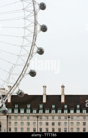 Basso angolo vista del London Eye e County Hall contro sky Foto Stock