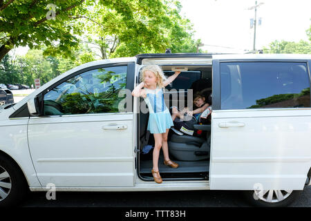 Ragazza carina appesa all'entrata mentre suor seduti in auto Foto Stock