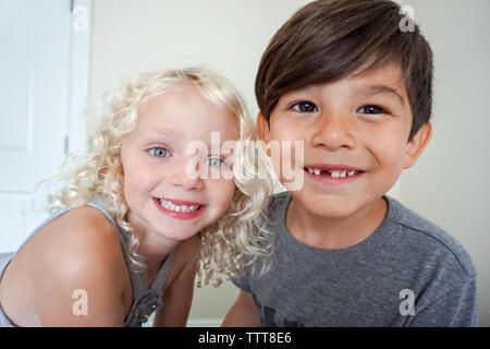 Un ragazzo e una ragazza fissando in telecamera closeup sorridente Foto Stock