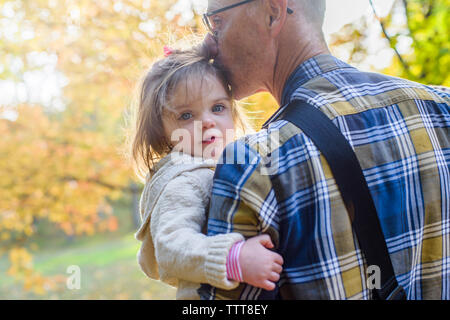 Ritratto di ragazza carina essendo portati dal nonno in posizione di parcheggio Foto Stock
