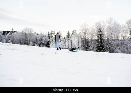 Padre figlio camminando in slittino snow white forest Winter Wonderland Foto Stock