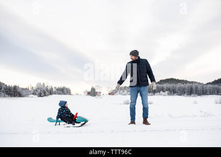 Padre figlio camminando in slittino snow white forest Winter Wonderland Foto Stock