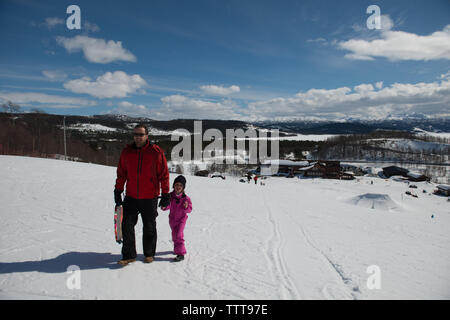 Padre di famiglia di capretto giocando in montagna innevata in winter wonderland Foto Stock