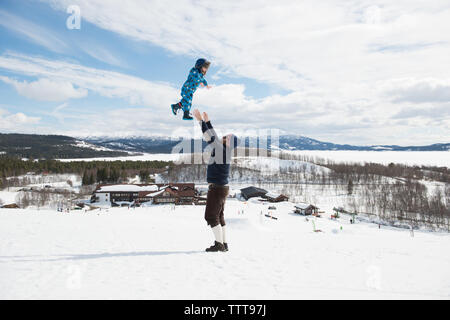 Padre figlio giocando in montagna innevata in winter wonderland Foto Stock