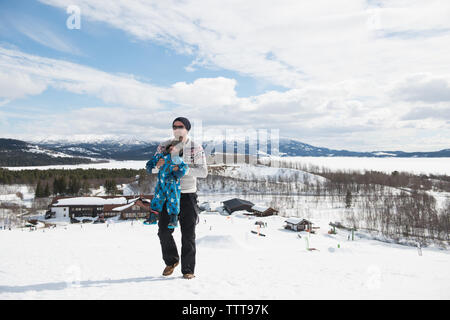 Padre figlio giocando in montagna innevata in winter wonderland Foto Stock