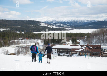 Padre figlio camminare in montagna innevata in winter wonderland Foto Stock