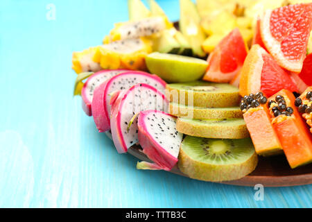 Succosa frutta esotica in blu sullo sfondo di legno Foto Stock